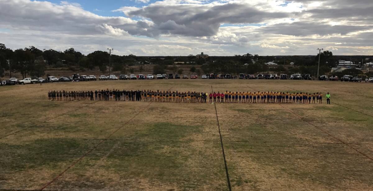 Showing Support: All three grades participated in the minutes silence on the field as his parents let go of yellow balloons to gain awareness for suicide prevention. 