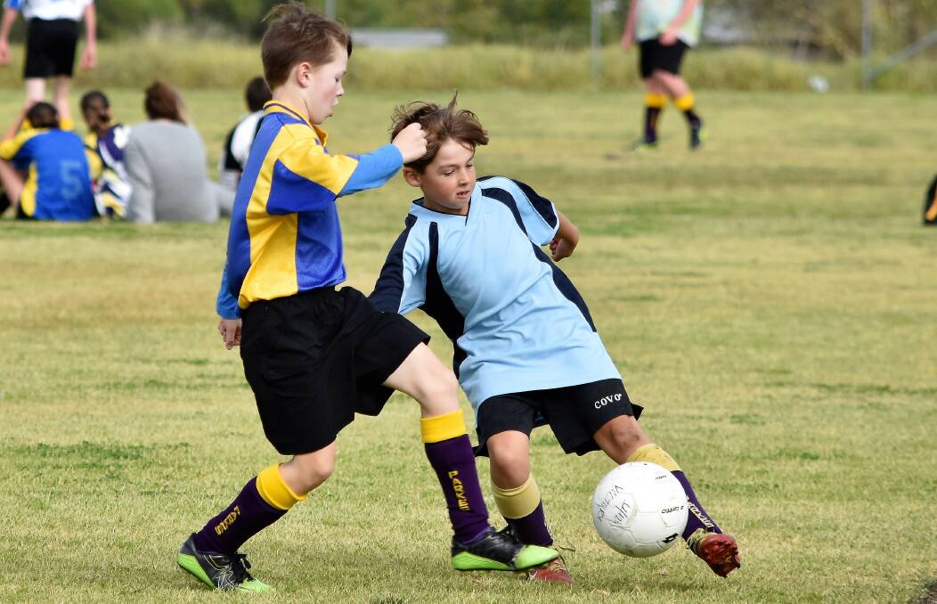Super Soccer Skills: Victory's Xander MacGregor and Olympics' Jake Dunn in an Under 12s junior soccer match at Harrison Park this season. Photo: Jenny Kingham