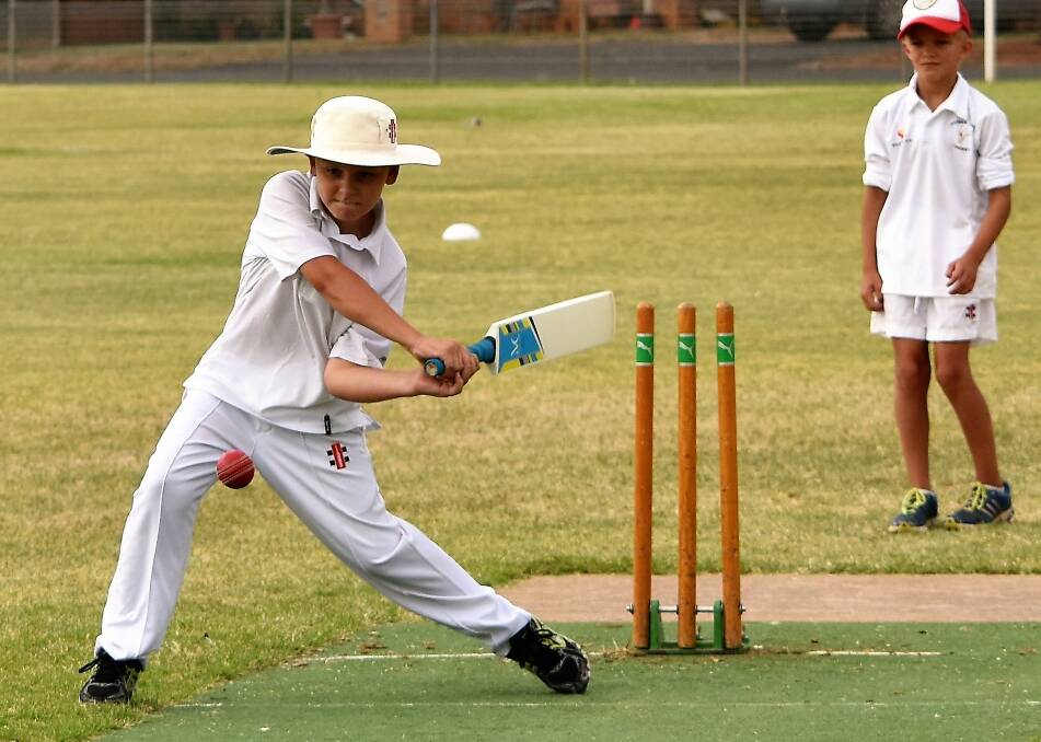 Batter Up: Young Matty Price throws his strength behind his batting during a junior cricket match at Keast 1 Oval between the Parkes Whites and the Hazell and Field team from Forbes.