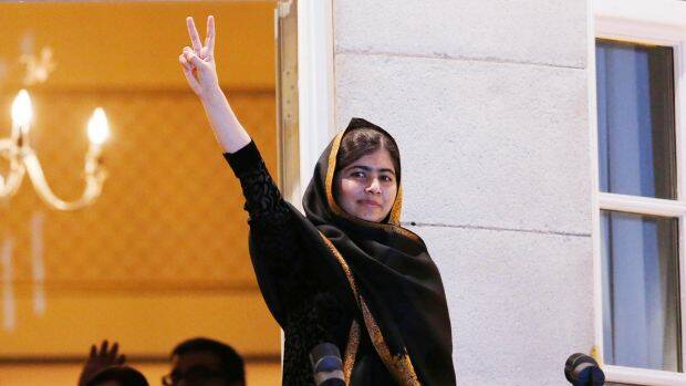 Nobel Peace Prize laureate Malala Yousafzai flashes a victory sign. 