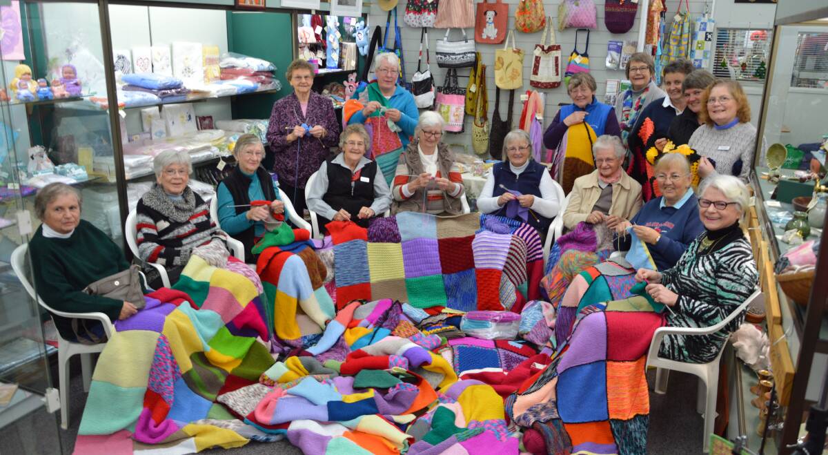 Knitting and nattering away under a mountain of colourful squares and rugs at the annual event at Craft Corner. Photo by Barbara Watt. 