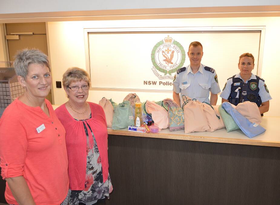 Quota members Raelene Rout and Janet O'Donoghue delivered emergency packs for victims of domestic violence to Senior Constables Daniel Greef and Sandra Barton. Photo by Barbara Watt. 