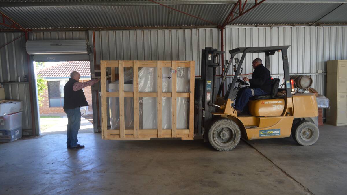 Peter John of Currajong Disability Service directing the forklift operator with the new CDS Paper Shredder.  