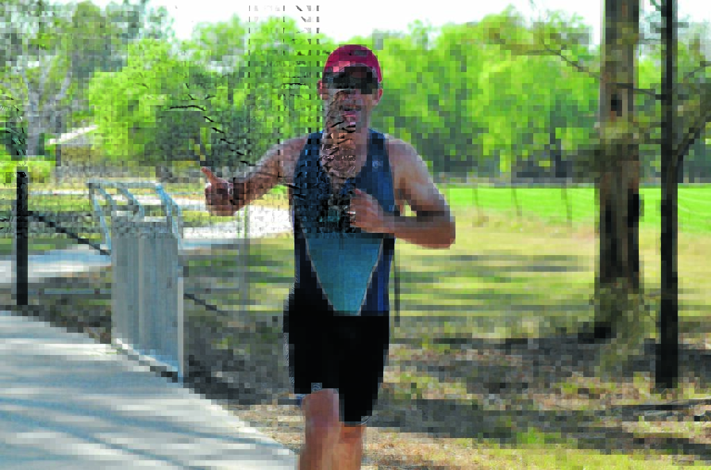 A happy participant returns from the Lake Forbes running track in the 2016 triathlon.