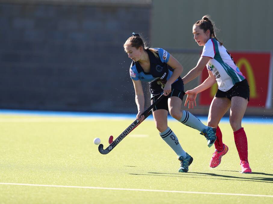 GOOD EFFORT: Souths' Emily Hurst works to keep the ball away from Bathurst City rival Kirsten Howard in Saturday's women's Premier League Hockey match at Bob Roach Field. Photo: PHIL BLATCH