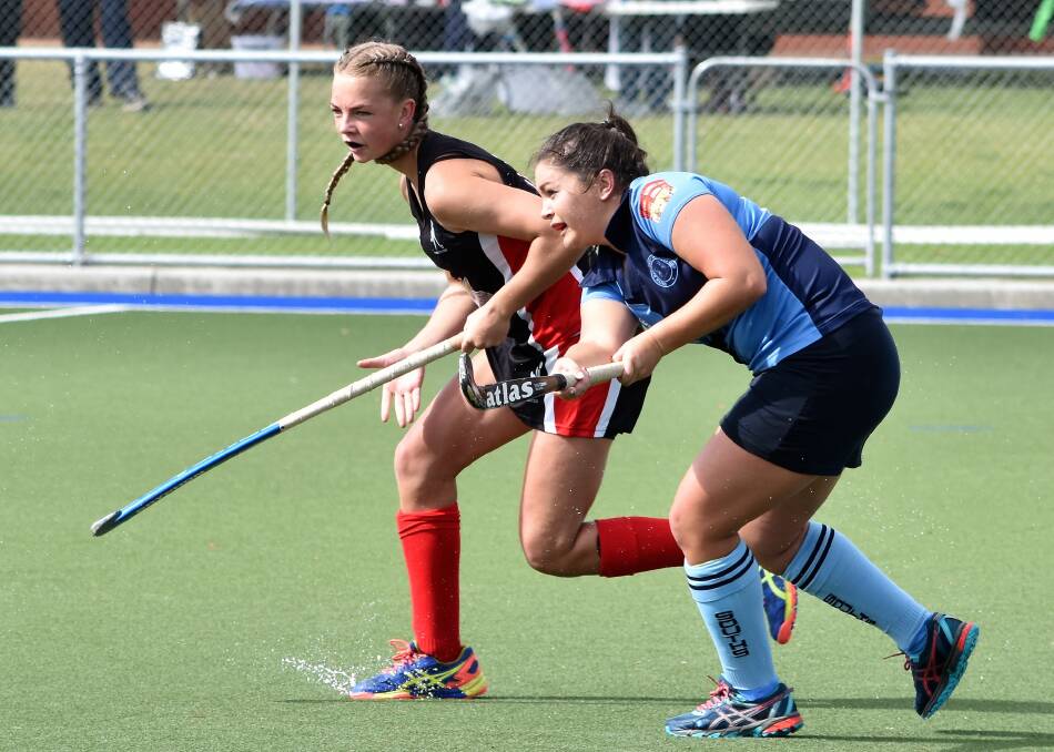 SAFTEY: Souths defender Tahnee Isedale clears the ball while under pressure from a Parkes rival in Saturday's women's Premier League Hockey match. Photo: JENNY KINGHAM