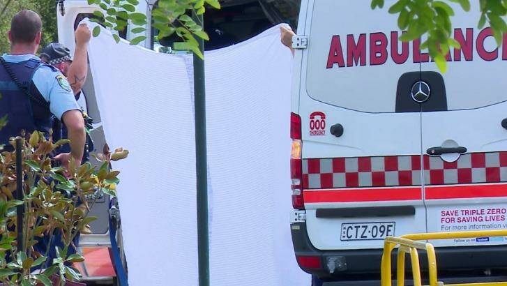 Police and paramedics take the woman from the house into an ambulance. Photo: TNV screengrab