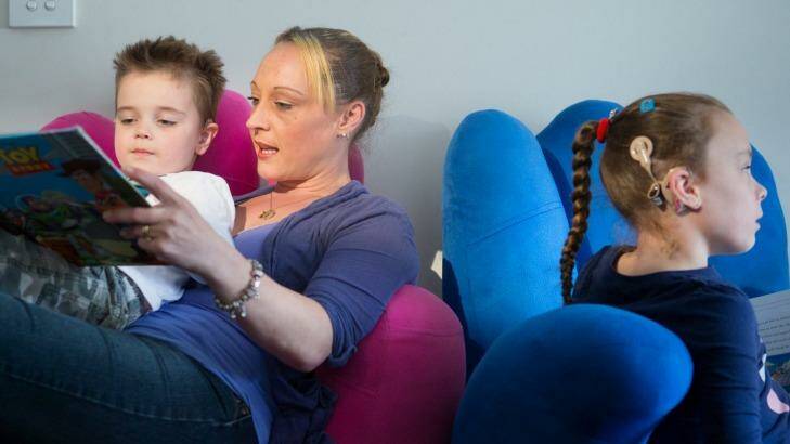 Lisa Thomas with her children  Brice (left) and Erin who will be missing out on her implant upgrade due to recent funding cuts. Photo: Simon Schluter