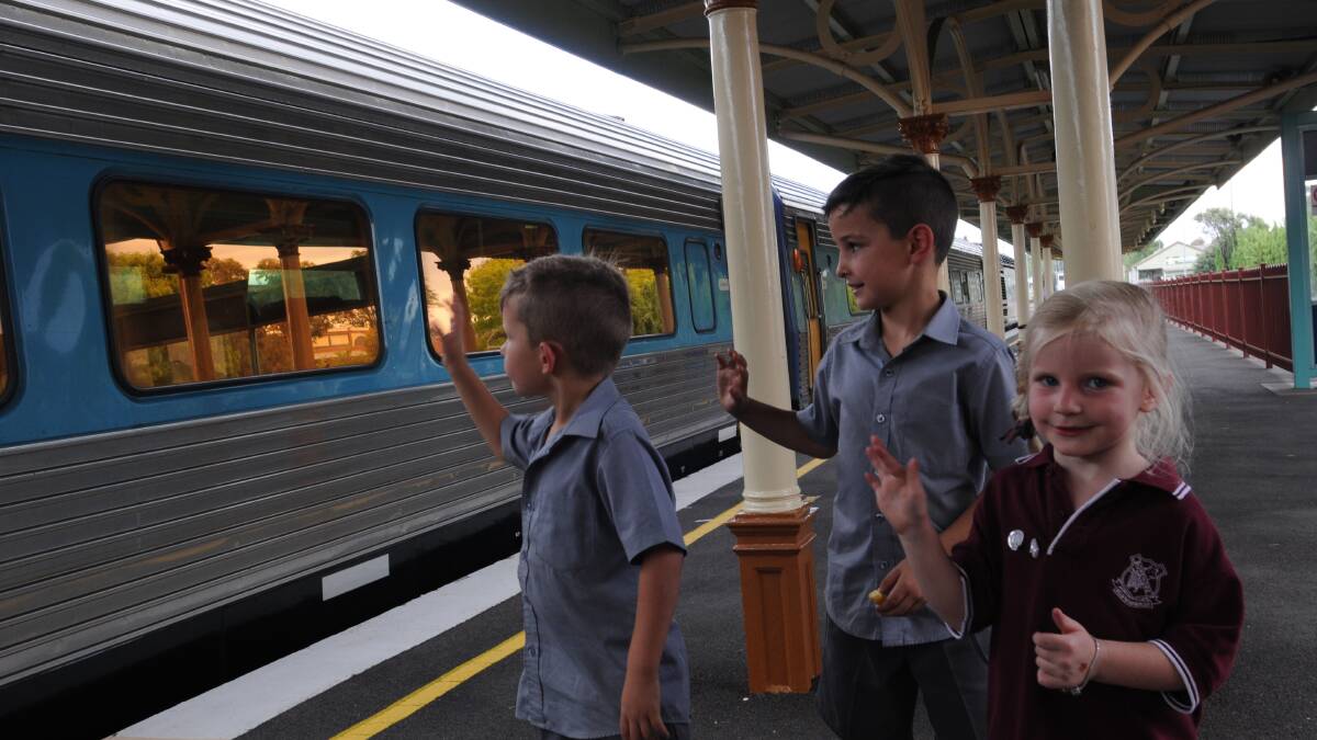 TRAINS A’GOIN’: Rowdy, Dexter and Quincy Roberts wave goodbye to the XPT as it leaves Orange yesterday afternoon.  Photo: MARK LOGAN 0311mlxpt