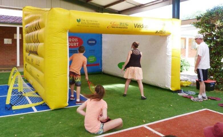 Ron Clarke (right) introduces some juniors to squash with the inflatable court. sub