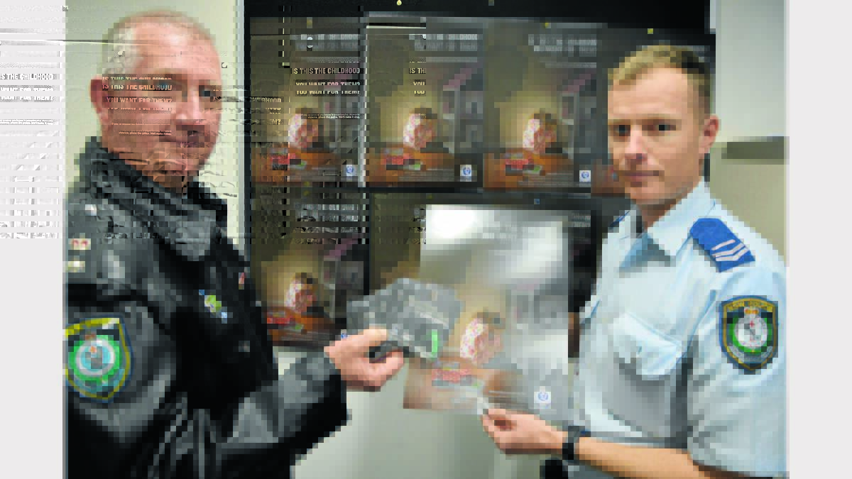 Superintendent Chris Taylor (Lachlan Local Area Command) and Senior Constable Daniel Greef with the coasters and posters which are part of the domestic violence campaign. 