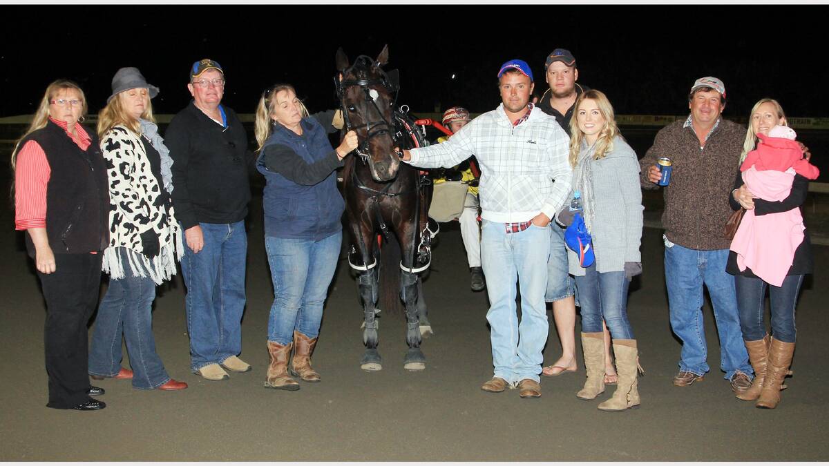 Forbes pacer, Loch Lochy scored an impressive win in the Les and Millie Whatling Memorial at the Trundle Night held by the Parkes Harness Racing Club last Thursday night. Pictured after the race are from left, Jocelyn Stewart, Jenny Sullivan, Ross and Angie (the Worker) Hodges, trainer Jason Gaffney and his wife Melissa, Warwick and Bruce Edgerton and representing the Whatling family, Sally Morrison hold baby Charlotte.