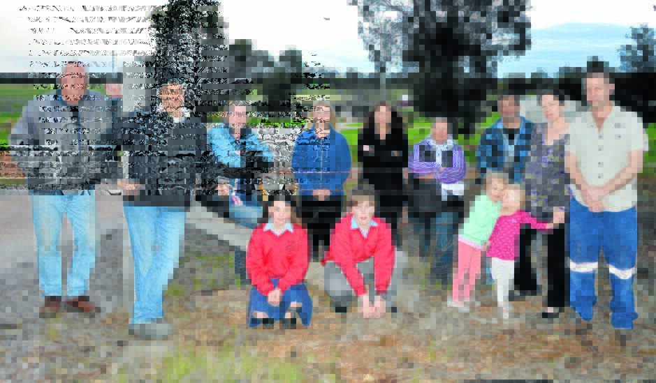 Pictured are some of the concerned residents in the Condobolin Road area, in front of the home of Adam and Aleta Pay.  The Parkes Tip is in the background, in the middle of the photo.  From left are TErry Clothier, Adam and Aleta Pay, Elizabeth Wythes, Katie Mapperson, Heather Wythes, Brett Mapperson, Annie and Matt Scherer; front, Tylah Mapperson, Hayden Pay, and Natalia and Corinne Scherer.   Photo: Roel ten Cate. 