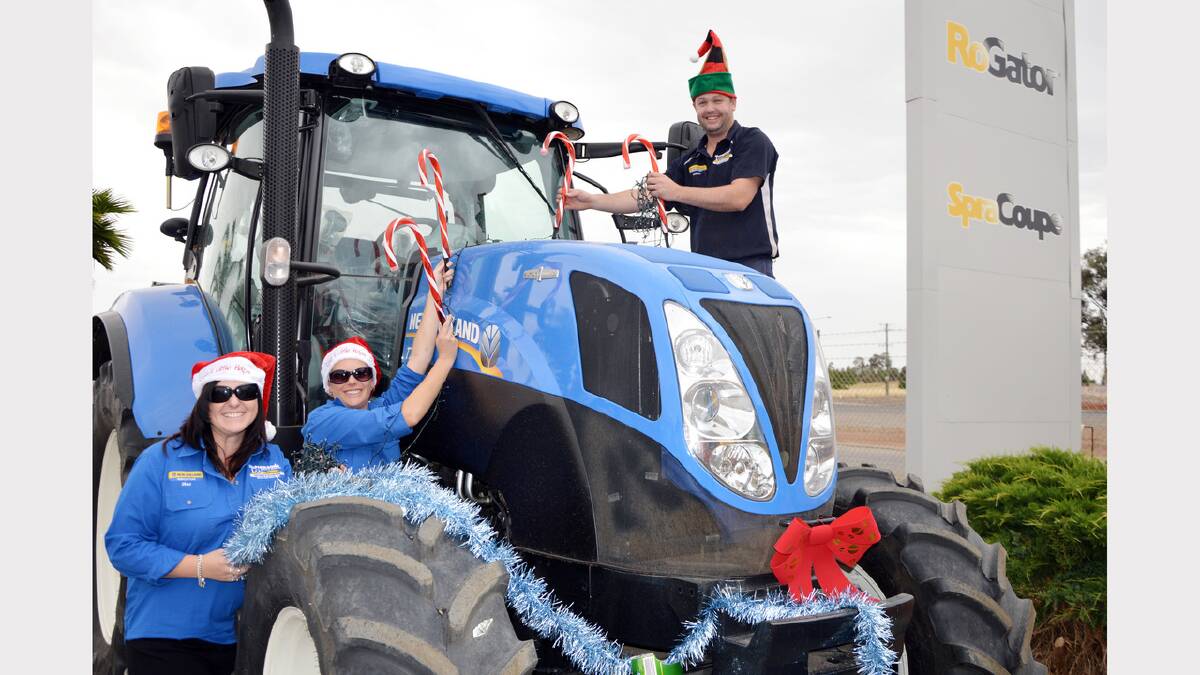 Even machinery dealers are getting into the spirit of the Chamber of Commerce “Parkes sparkles” Christmas campaign by lighting up some of their large items of equipment.  We snapped McPherson’s Machinery Parts and Service staff members, Sharon Charlton, Renee Thompson and Nathan Jennings decorating a New Holland tractor at their premises on the Forbes Road.  They will go even bigger in the days ahead, dressing up a T9505 500 horsepower tractor so it can be seen from the road. 