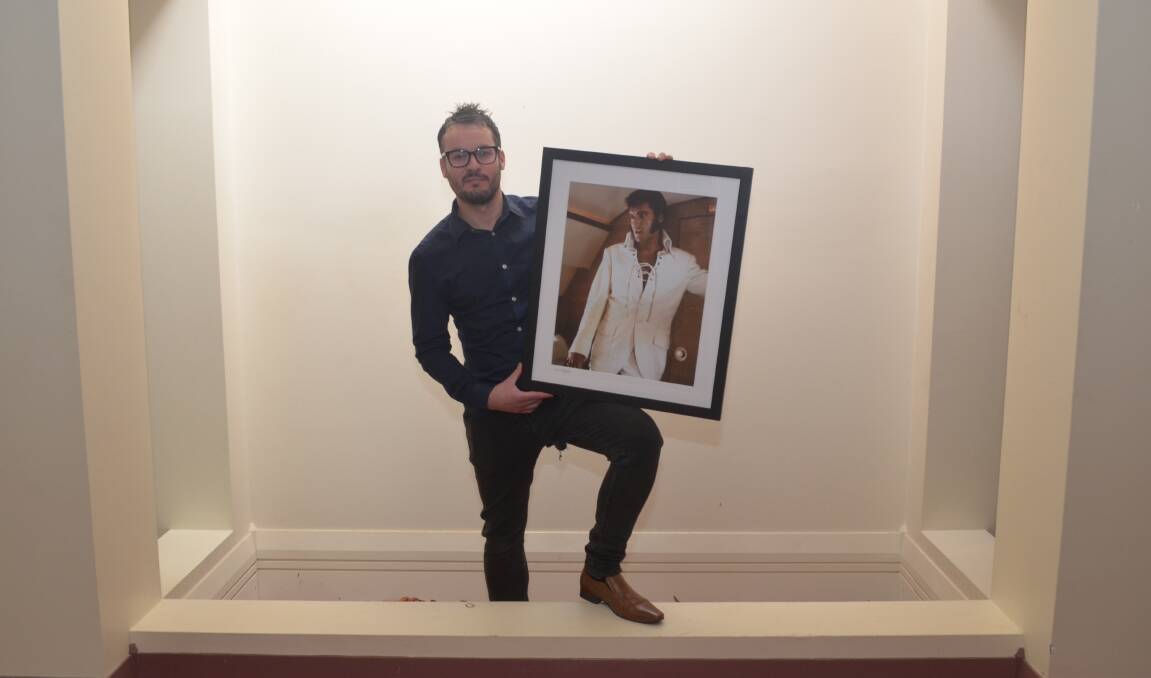 THE KING: Elvis exhibition curator Adam Nicholson with a photo of Elvis aboard Frank Sinatra's private jet. Photo: DECLAN RURENGA 0714drelvis3