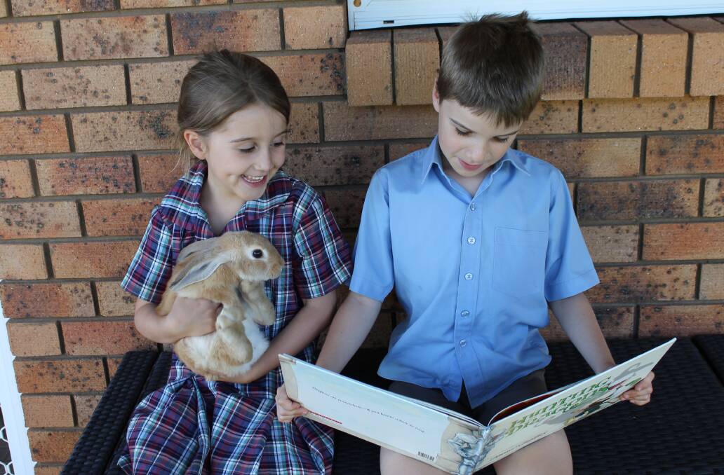 FURRY FRIEND: Parkes students Logan and Aliza Roberts decided to read to their little furry friend after school one day.