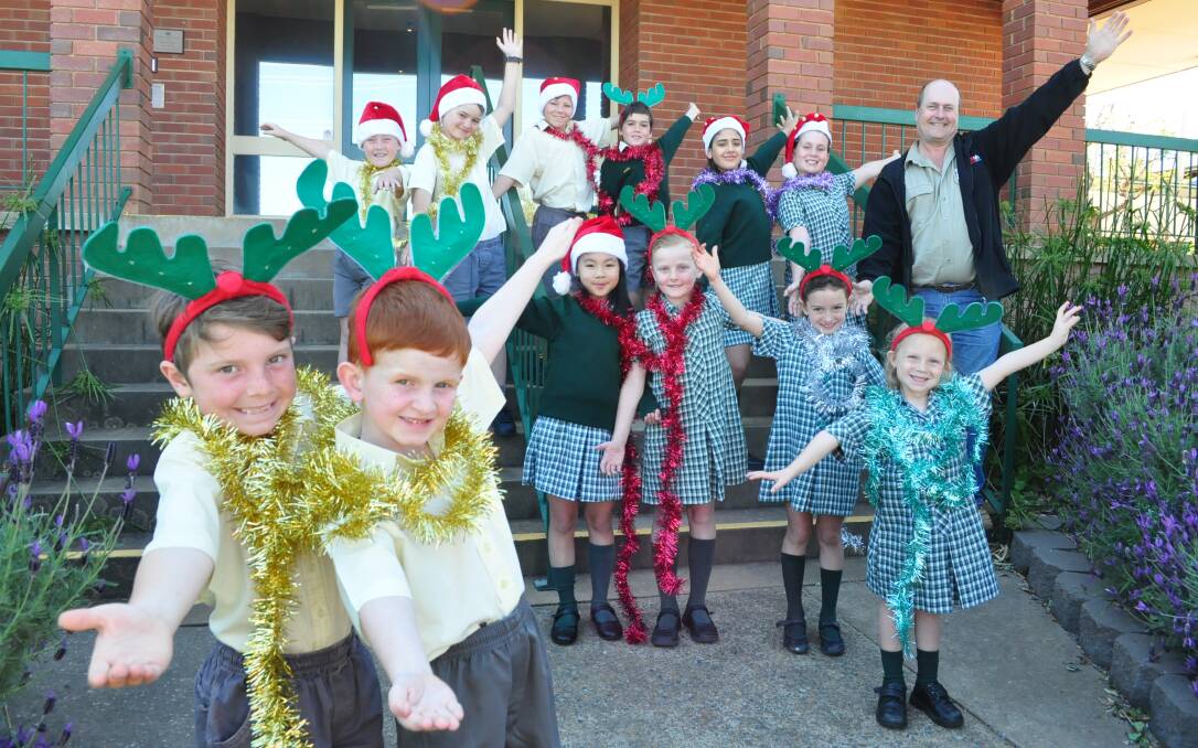 WELCOMING NEWS: Holy Family students, front: Benji Redfern and Declan Quade, middle: Kathy Duong, Joan Carolan, Poppy Fisher and Mia Gorring, back: Beau Shearer, Toby Cox, Charlie Summerhayes, Ashton Scally, Dema Samir and Trinity Gatt, and Parkes Action Club member Alan Ward are happy the Christmas parade is making a return.