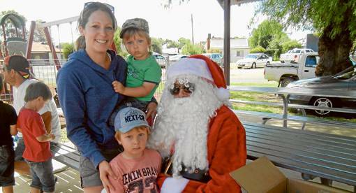 GRENFELL: Ronan and Finn Hutchens with their mum Katrina were happy to receive a bag of sweets and a gift from Santa Claus when he made an appearance at the Lions Club Market Day at the at the Lions Park at the Grenfell Railway Station on Sunday November 24.