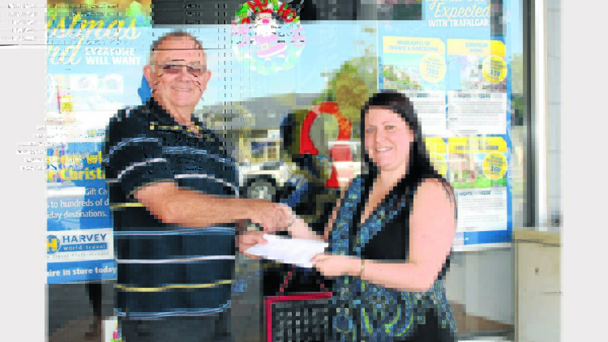 Trudy Brown receives her wonderful holiday voucher from Parkes Rotary Club President Col Offner. 
