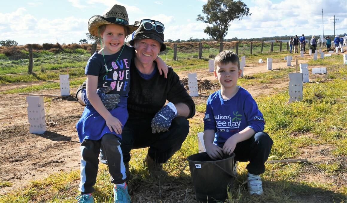NATIONAL TREE DAY: Beth and dad Kieren Deland with Jenson Howard helped to plant 300 trees in Akuna Road on Sunday. Photo: Jenny Kingham.