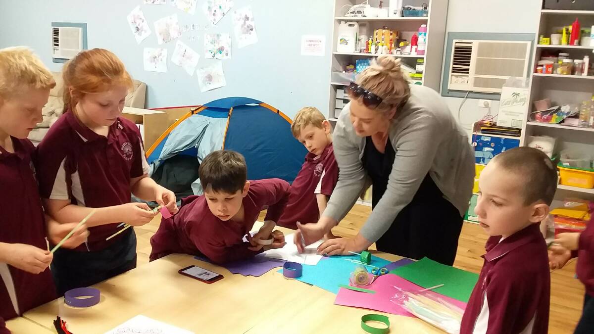 Fabulous Fun: Parkes PCYC's OOSH Coordinator Katie Spence helping youngsters create their gliders. Photo: Submitted.