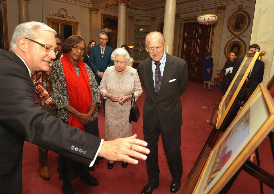 Andrew Todd, left, gestures as Queen Elizabeth II, Prince Philip and Lenie Namatjira, the granddaughter of Aboriginal artist Albert Namajtira look on, during a private meeting with members of his family who presented the royal couple with two new pieces of artwork, at Buckingham Palace in 2013. Picture: Getty Images