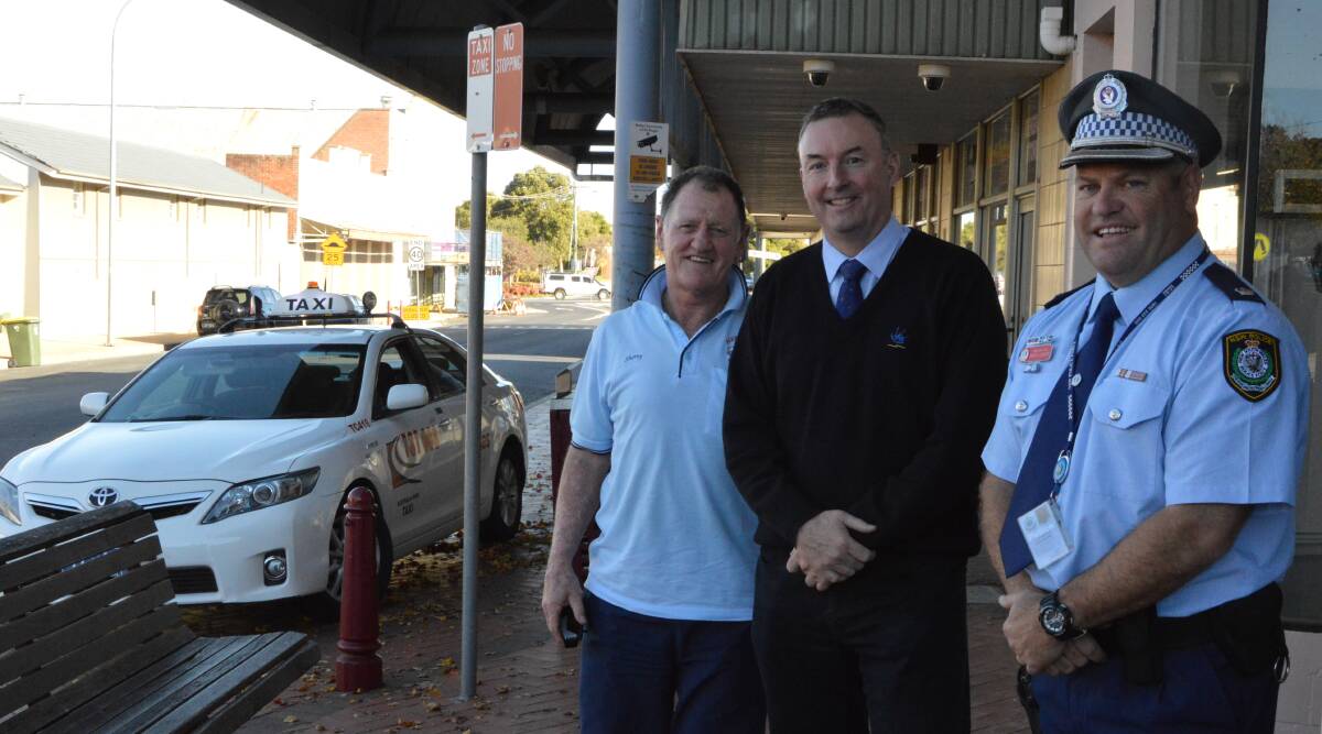 TAXI RANK: Parkes taxi driver Ray Neilsen, Parkes Shire Council’s Information Services Manager Anthony McGrath and Chief Inspector David Cooper check out the old analogue cameras at the Parkes taxi rank.
