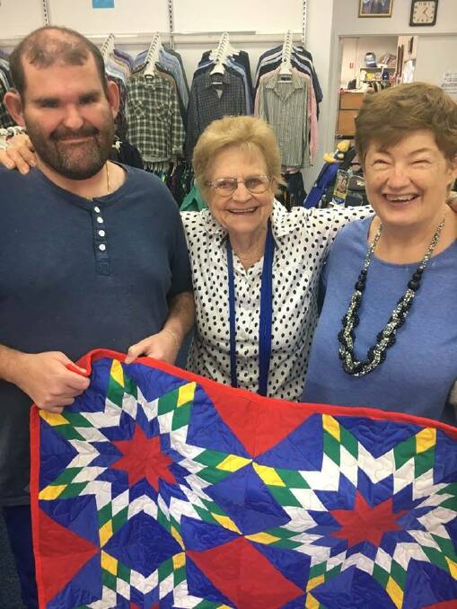 Shannon Miller, Patricia Davis and Karen Willis. Shannon and Karen are presenting the quilt to Patricia who is from St. Vincent De Paul. 