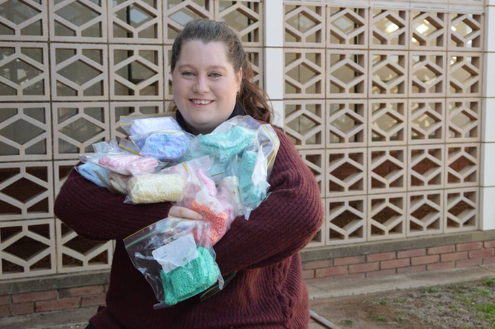 Megan with all she could hold of the beautifully hand made premature baby sets.