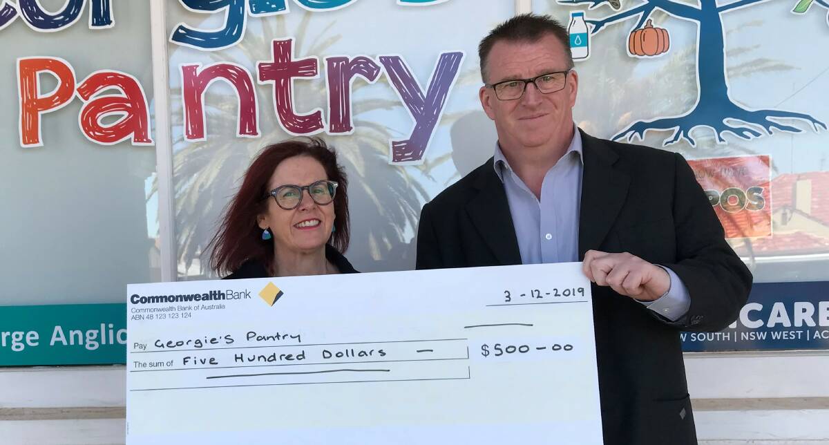 MAKING A DIFFERENCE: Anglicare Manager Natalie Quince accepted donation from Commonwealth Bank Parkes Branch Manager Troy Peters on behalf of his staff. Photo: Supplied.