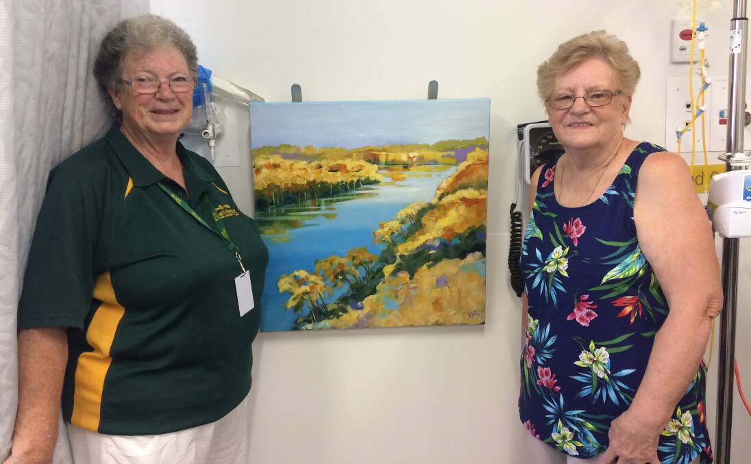 A TOUCH OF BEAUTY: Pat Bailey and Adrianne Brown from Parkes Can Assist with the new painting by local artist Karen Ritchie in the oncology unit at the Parkes Hospital. Photo: Contributed