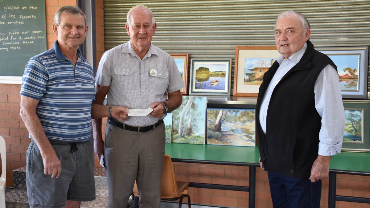 WORTHY CAUSE: Parkes Painting Group member Kim Chambers presented a cheque to Bob Brookes and Geoff Boland from Parkes Legacy. Photo: Barbara Reeves. 