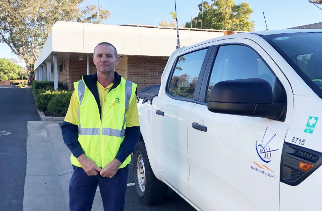 Parkes Shire Council staff member Tim Gillogly is wearing a yellow lapel ribbon and displaying a yellow ribbon on his work vehicle as part of Yellow Ribbon National Road Safety Week.
