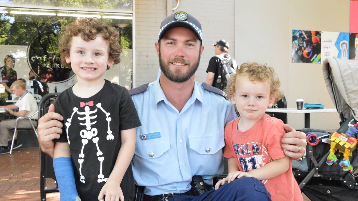 SMILE: Last year's coffee catch-up wasn't just for adults, Jonah and Elliott Gould met local officer Senior Constable Joel Breaden. Photo: Christine Little.