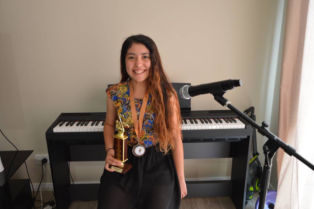 TALENT: Hannah Dun with the trophies she won busking in the regional final in Peak Hill and the grand final in Cooma of the Australian National Busking Championships. Photo: Barbara Watt.