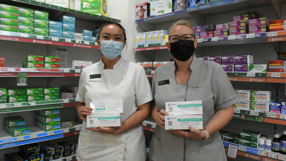 Parkes Pharmacy pharmacist Vee Vien Higgins and Bron Lowe encourage concession card holders to collect their free Rapid Antigen Tests. 
