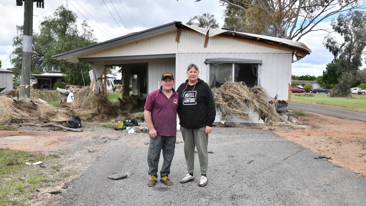 George and Sue Cross stand in front of the house that washed down the street towards Mavis and those trying to rescue her. Picture by Carla Freedman