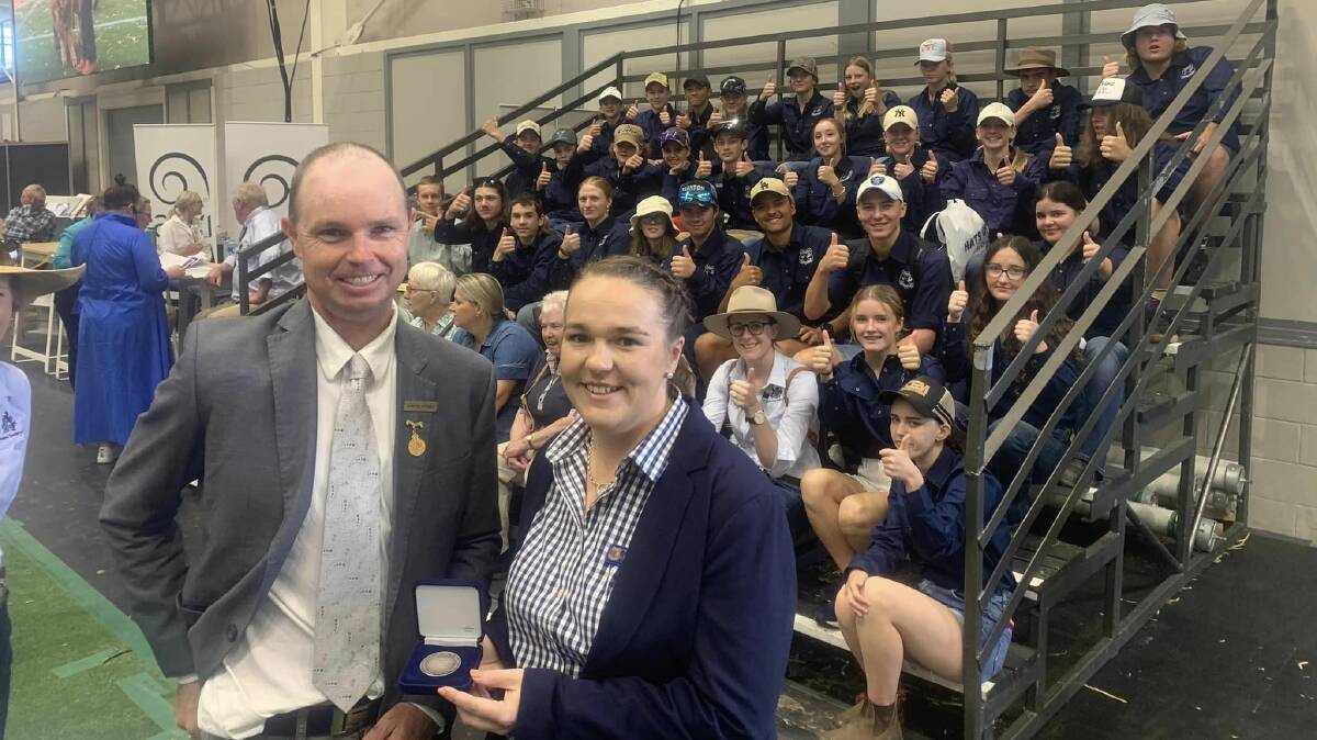 RAS sheep and wool committee chair Joseph Byrnes presented Heather Earney with the prestigious RAS Youth Contributor medal at Sydney Royal as she supervised the students' visit to the Merino judging on Tuesday morning. Picture supplied
