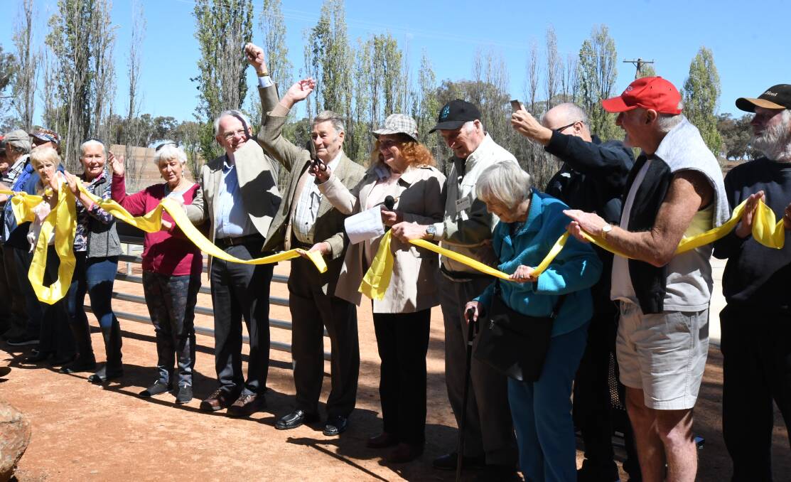 IT'S OPEN: David Hill and Jimmy Napper (arms raised) cheer as Old Fairbridgians form a line to watch Maggie Maclauchlan cut the ribbon to open the Fairbridge Childrens Park. Photo: CARLA FREEDMAN