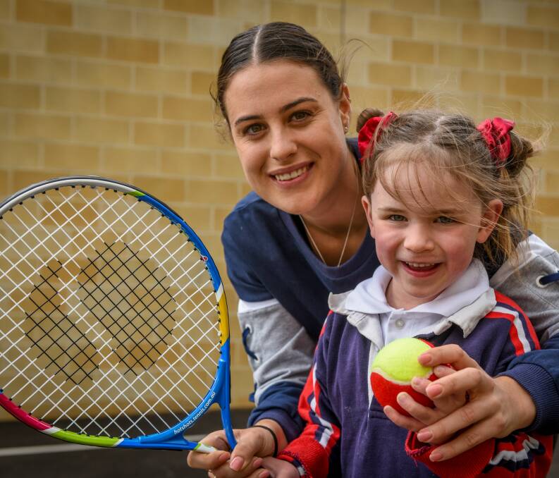 Beaming: Kim Birrell with six-year-old Alice Wynne, after presenting the Prep class with new tennis racquets at Launceston Preparatory School. Picture: Paul Scambler.