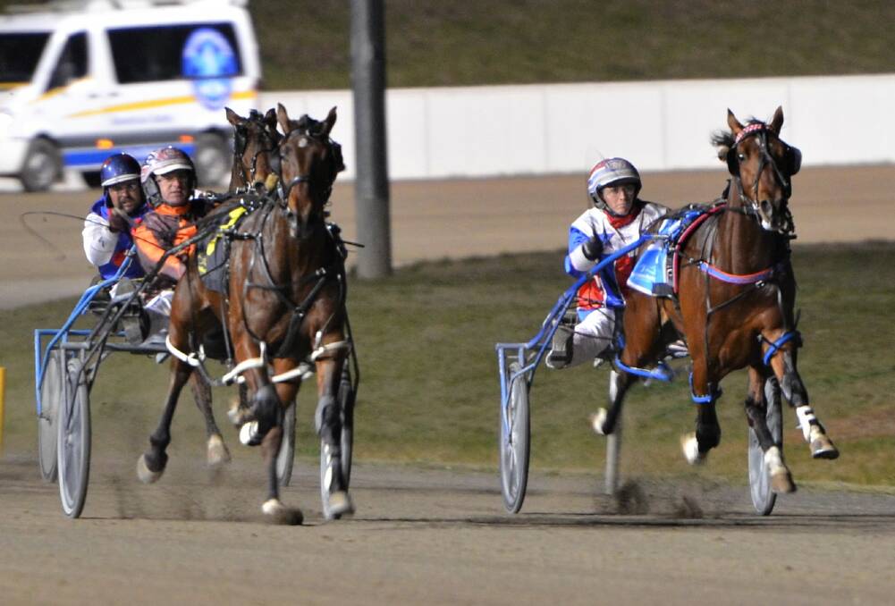 THE BATTLE: The Mat Rue driven Bling It Up (left) held off favourite Bettor Keppel (right) to win at the Bathurst Paceway on Friday night. Photo: ANYA WHITELAW