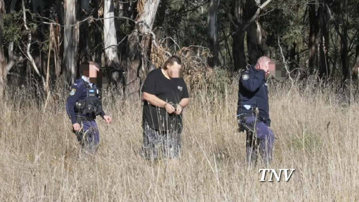 Jason Eggins being led out of Gosling Creek reserve after he set fire to a car nearby. Picture by Troy Pearson/TNV.