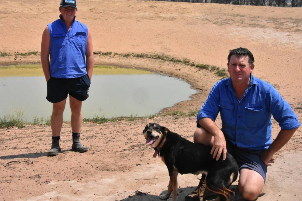 EXTREMELY DRY: NSW Farmers vice president Chris Groves and his son Oliver inspecting one of the last dams on their Cowra property holding water.