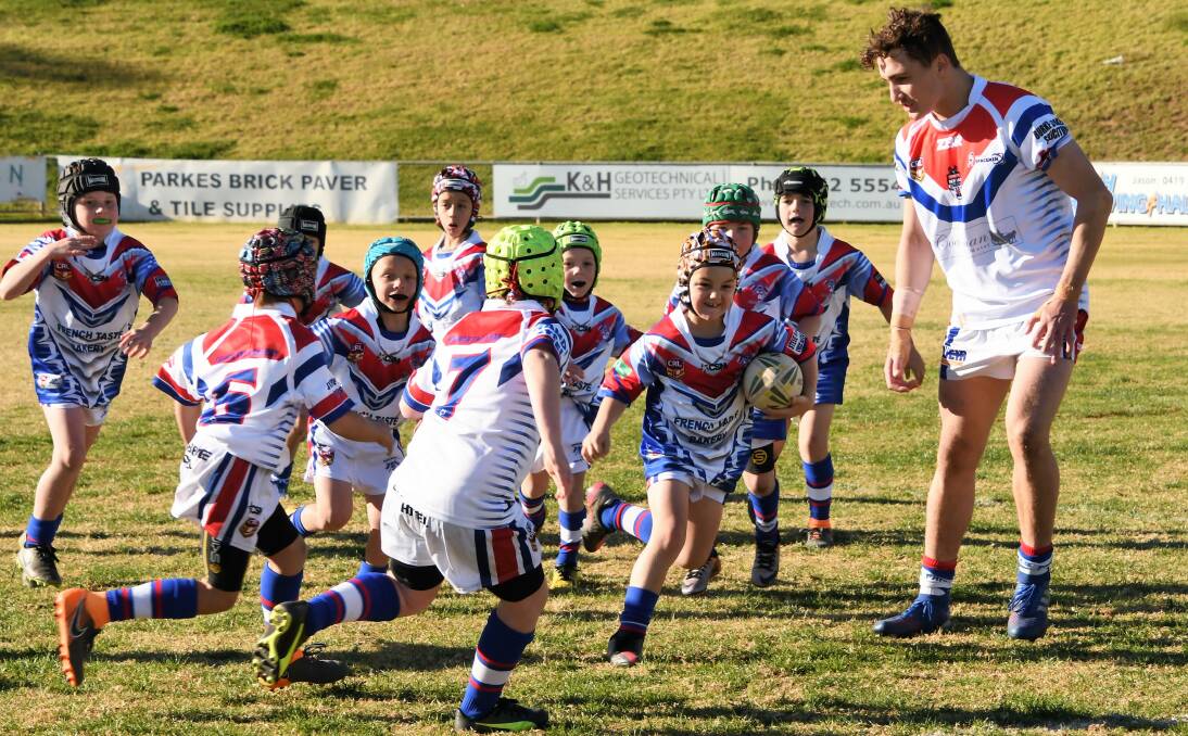 JUNIORS: Ben Lovett supervises play between the 7-8 years players during half time of the Parkes Spacemen first grade match on Sunday. Pictured is Fletcher Hall with the ball. Photo: Jenny Kingham.