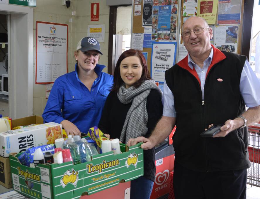 Drought Angels representative Lou Green with grocery grabber Maddie Hanns and Peter Boschman of Cunningham's IGA.