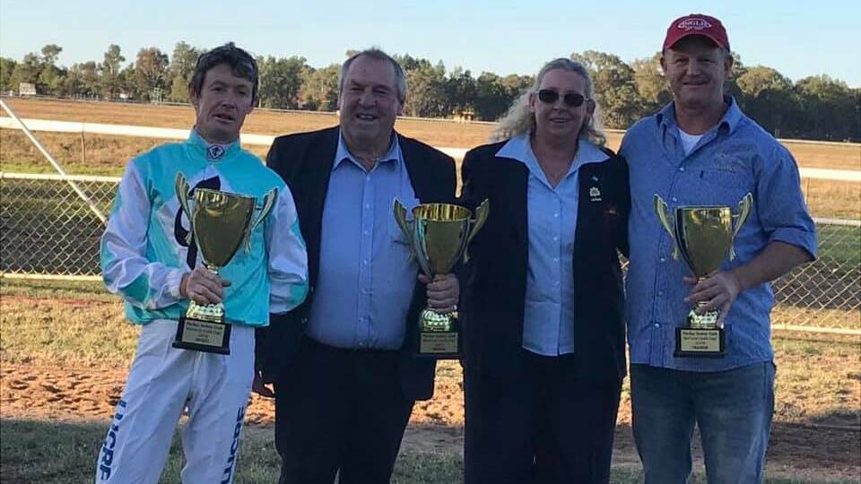 DONE IT AGAIN: Wagga trainer Chris Heywood (right) and jockey Mathew Cahill (left) get the spoils after Class Clown's Parkes Cup win on Sunday. Photo: PARKES JOCKEY CLUB