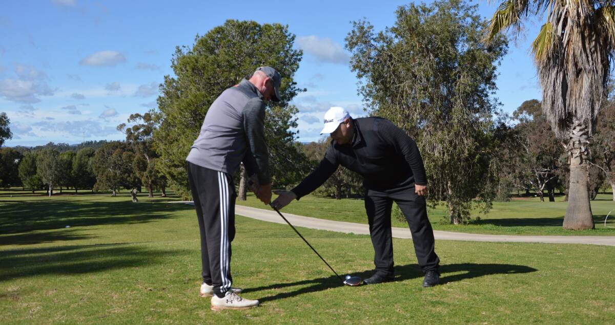 DRIVING FORCE: Jake instructs Parkes Golf Club member Scott Mackenzie. Photo: Kristy Williams 