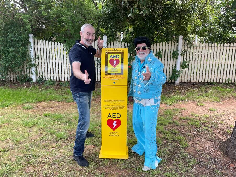 YOU BEAUTY: Greg Page and Parkes Shire Mayor, Cr Ken Keith OAM with one of the AED boxes in town. Page has fourth-largest collection of Elvis Presley memorabilia in the world, hence the suit. Photo: SUPPLIED.