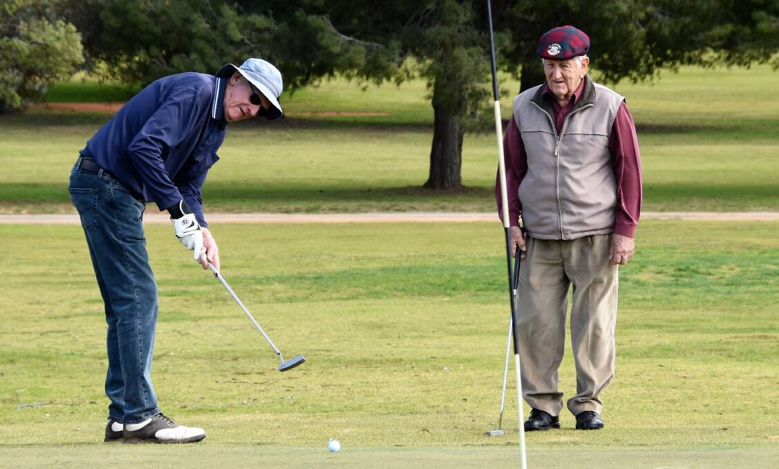 GOOD FORM: Dub Rogers (pictured putting, watched by Bob Barter) hit a solid 35 points at the Parkes Golf Club's 4BBB championships on Saturday. Photo: JENNY KINGHAM.