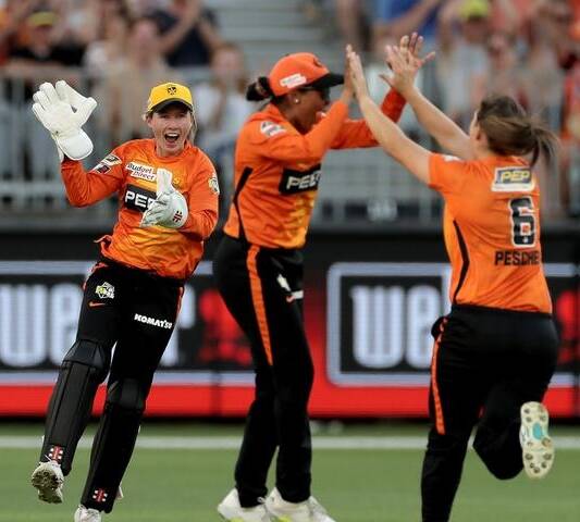 BIG EFFORT: The Perth Scorchers celebrate winning their first title at Optus Stadium in the WBBL|07 final last week. Photo: AAP.